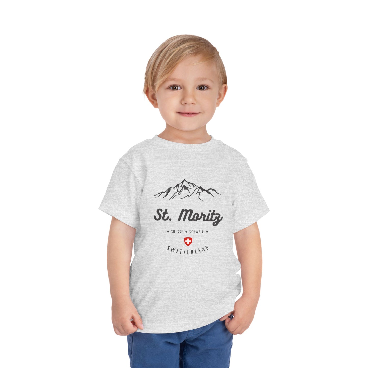 Toddler wearing a St. Moritz-themed t-shirt featuring mountains and the Swiss flag.