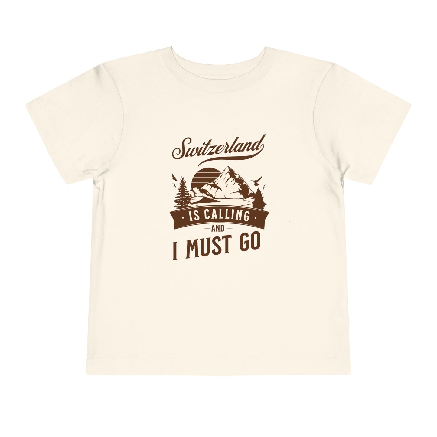 Natural kids’ t-shirt with “Switzerland Is Calling” mountain print design in outdoor setting