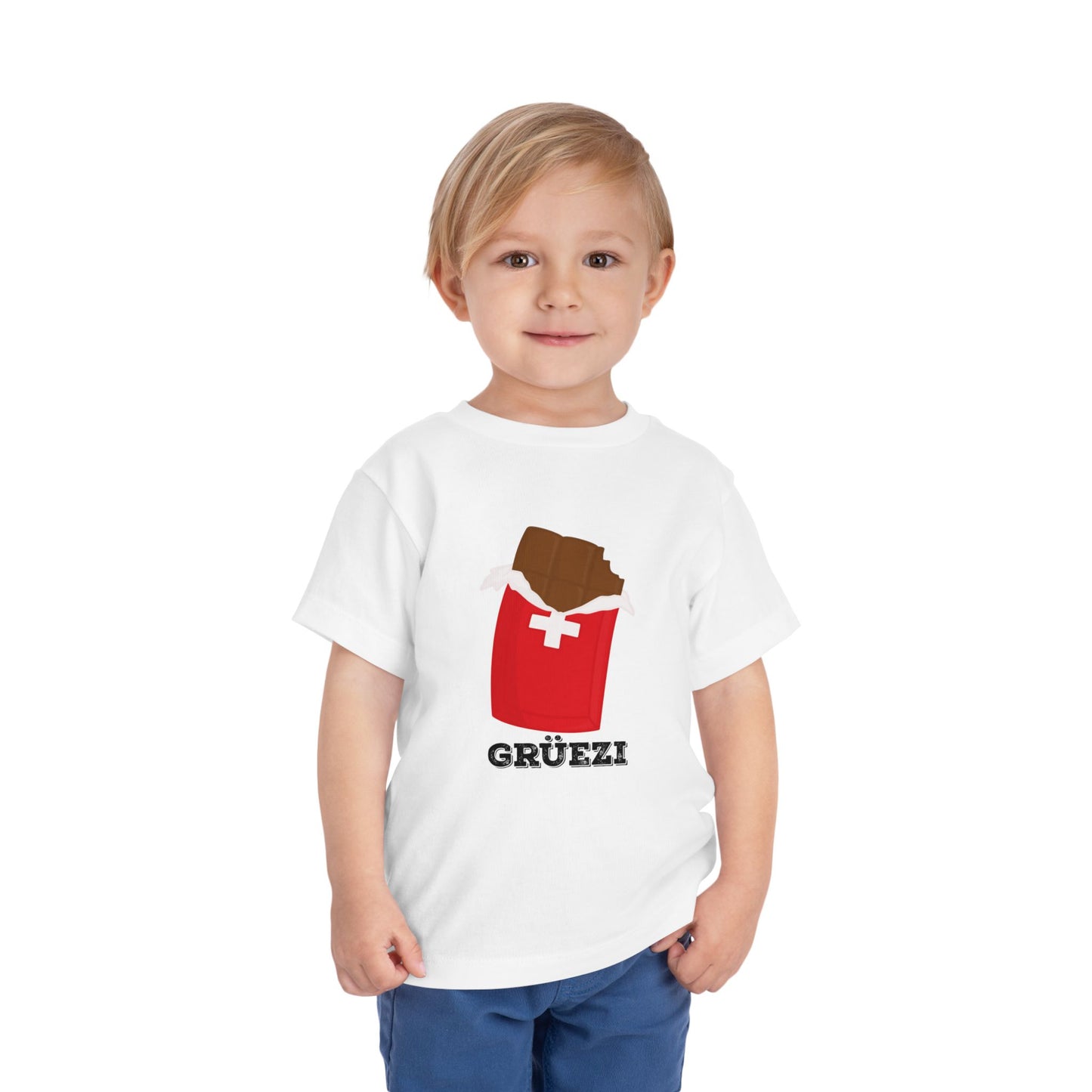 Cute toddler wearing a white Swiss chocolate-themed t-shirt with "Grüezi" text