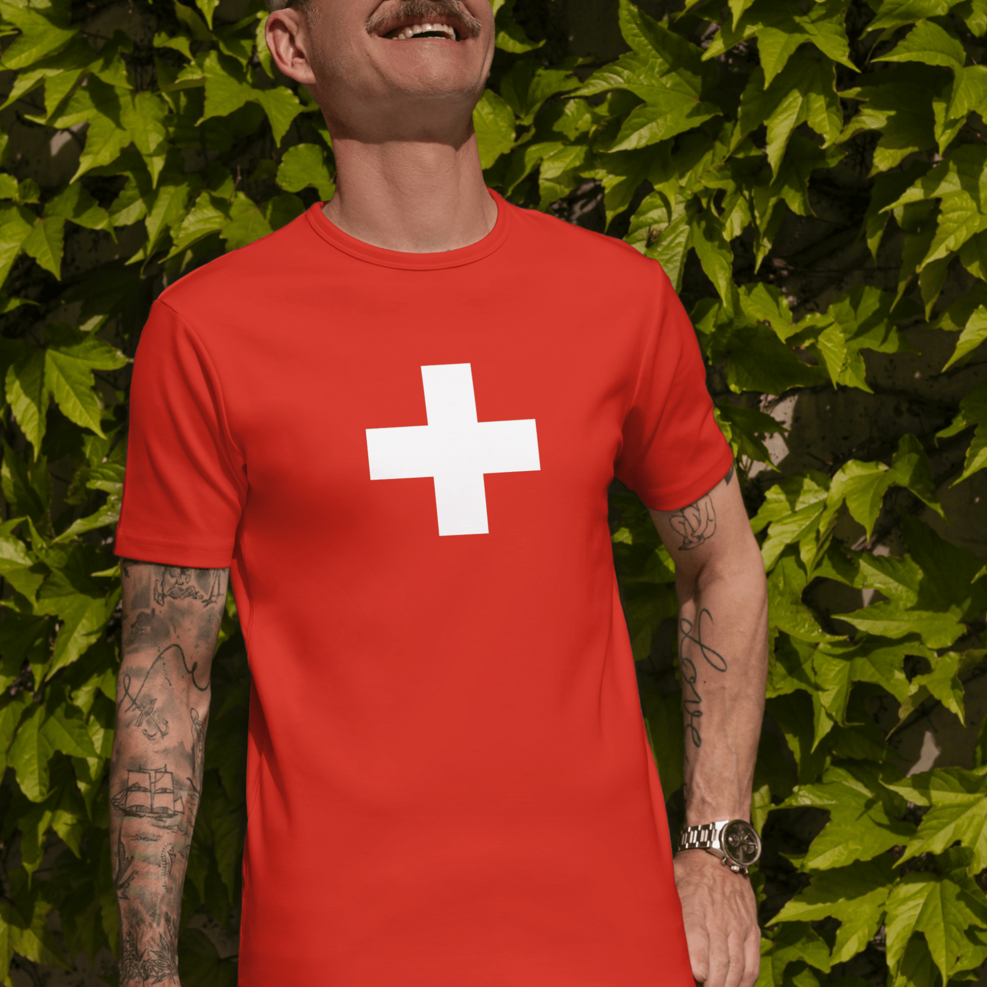 Male model in a vibrant red t-shirt featuring the iconic Swiss flag design, perfect for travel, supporting Swiss teams, and national celebrations.