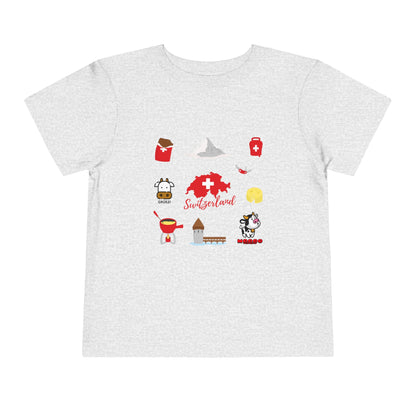 Flat lay of Switzerland toddler shirt with iconic Swiss elements like map, Swiss army knife, and chocolate