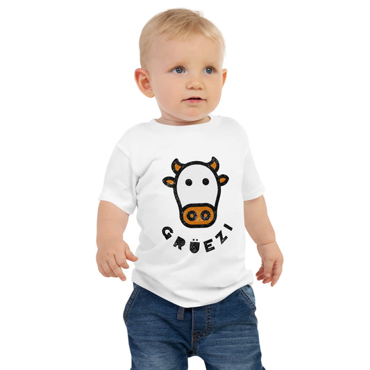 Baby wearing a white t-shirt with Swiss cow and Gruezi text design