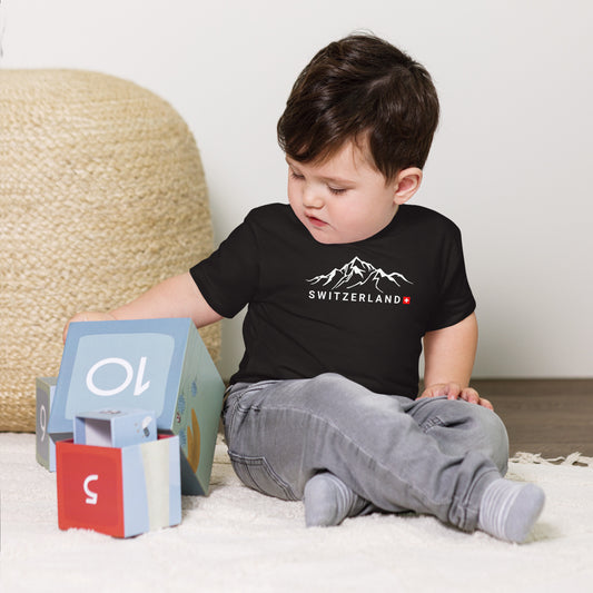 Baby wearing black Switzerland t-shirt with minimalist mountain and Swiss flag design