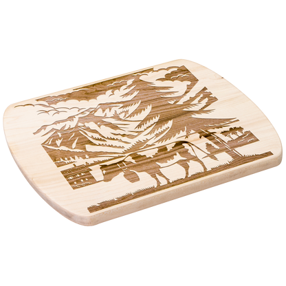 Scherenschnitte cutting board with Swiss cow silhouette against mountain backdrop