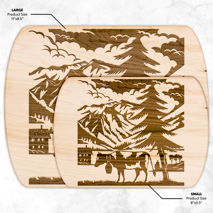 Premium wooden cutting board featuring Swiss cow papercut design with Glarus peaks, ideal for cheese serving and rustic kitchen display
