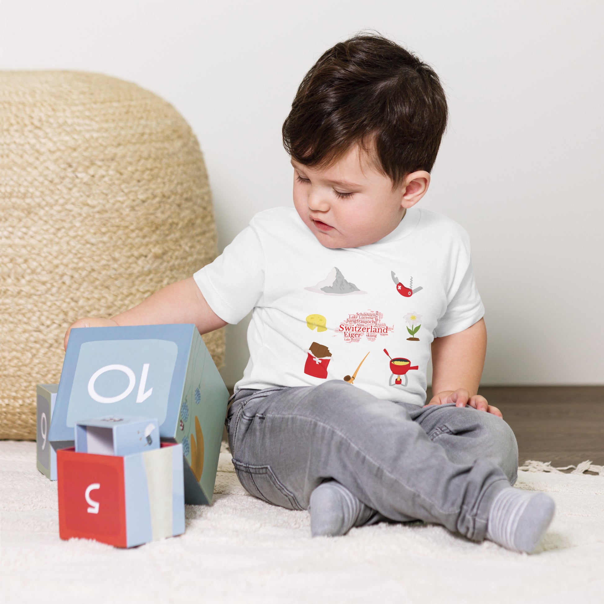 White baby t-shirt featuring Swiss landmarks and icons