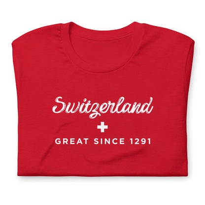 A folded red t-shirt with white printed text reading 'Switzerland' 'GREAT SINCE 1291' with a small Swiss Flag white cross in the center