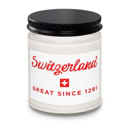 A white glass jar candle with a black metal lid and a white label featuring red text that reads 'Switzerland' and 'GREAT SINCE 1291' with a small Swiss flag icon.