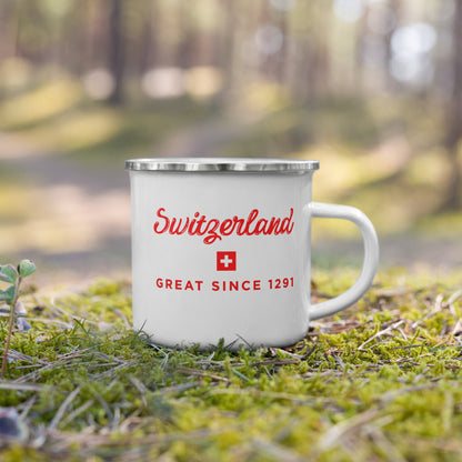 A white enamel camping mug with a silver rim. The mug features red text reading 'Switzerland' and 'GREAT SINCE 1291' with a small Swiss flag graphic.