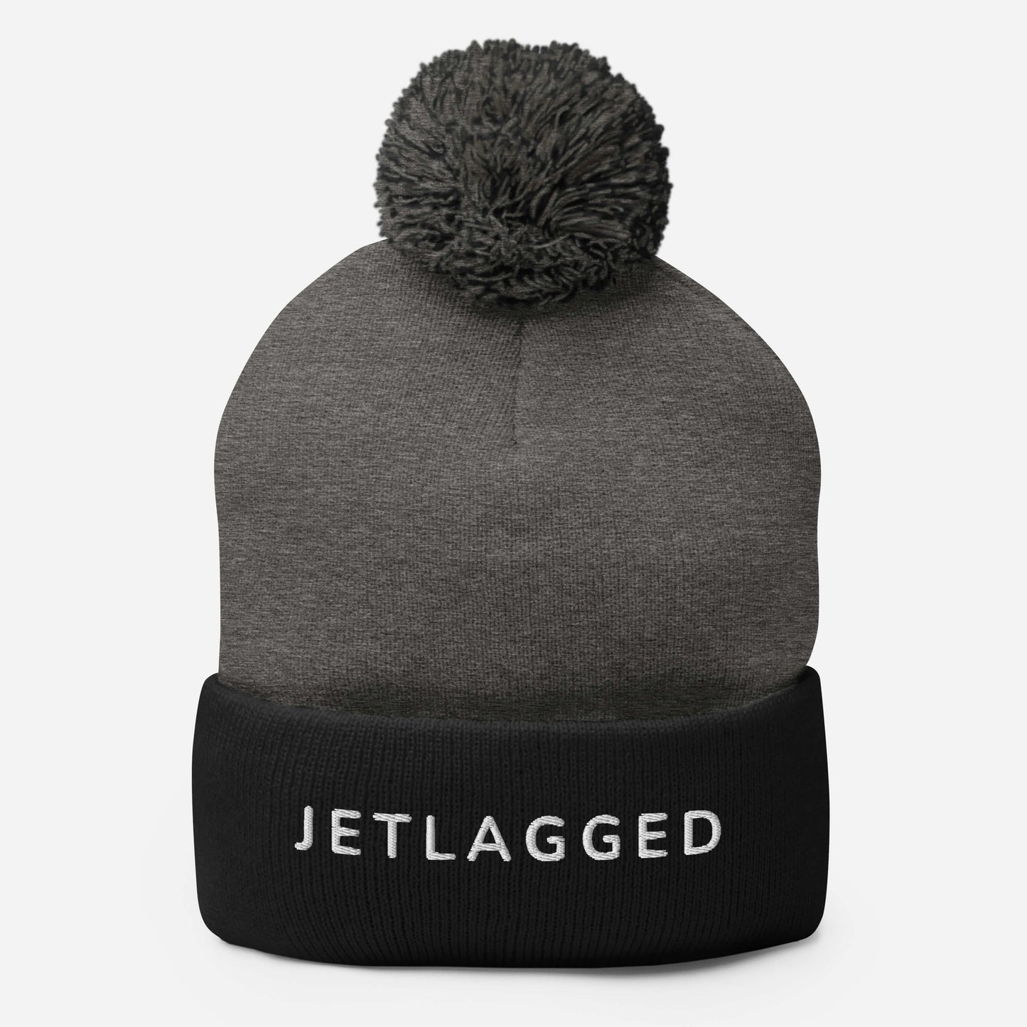 Jetlagged pom-pom beanie with embroidered text for travelers