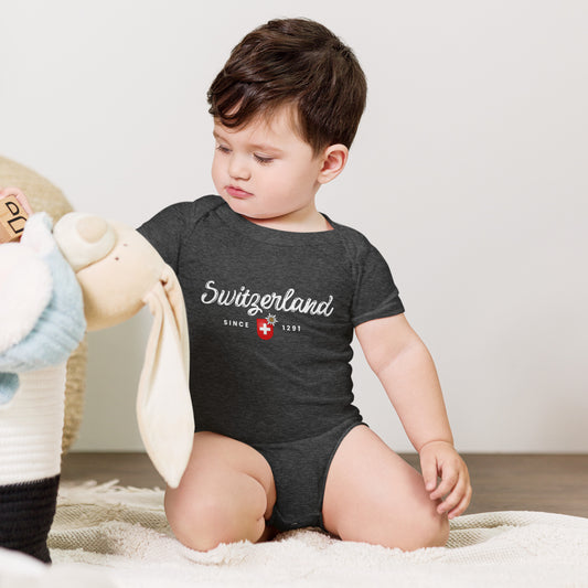 Baby wearing dark gray Switzerland Since 1291 onesie with red Swiss flag