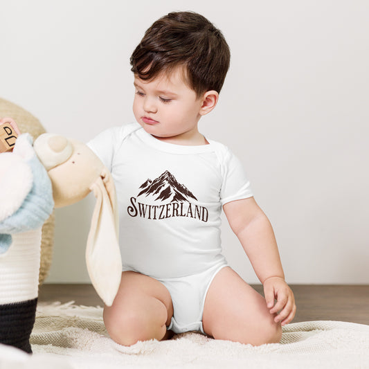 Baby wearing minimalist Switzerland bodysuit in white with mountain design.