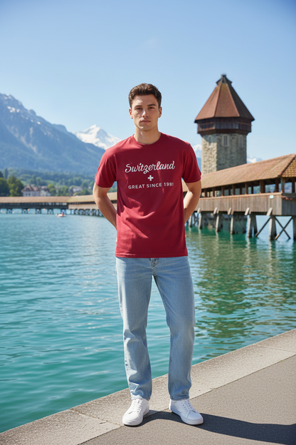 Man wearing Switzerland Great Since 1291 red Comfort Colors t-shirt by Lake Lucerne with Chapel Bridge and Swiss Alps in the background