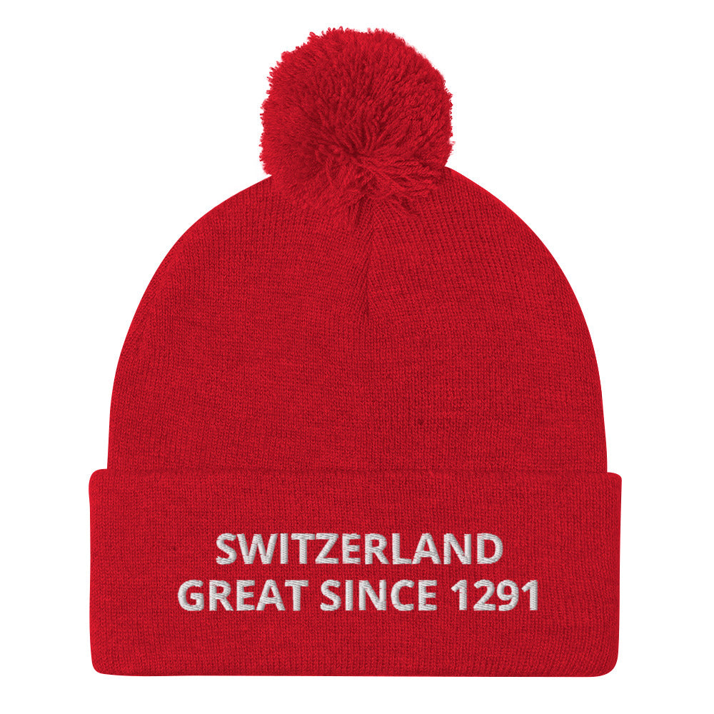 Red knit Switzerland pom-pom beanie with white “SWITZERLAND GREAT SINCE 1291” embroidery
