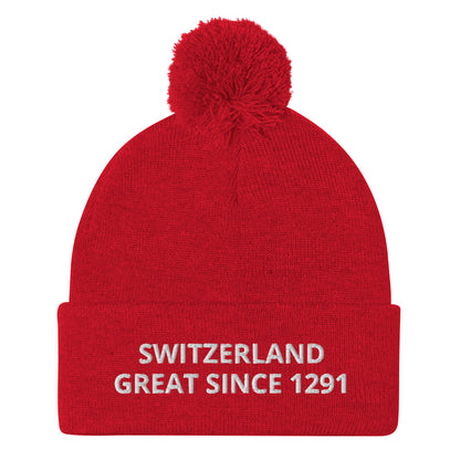 Red knit Switzerland pom-pom beanie with white “SWITZERLAND GREAT SINCE 1291” embroidery