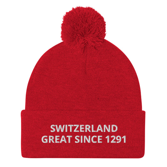 Red knit Switzerland pom-pom beanie with white “SWITZERLAND GREAT SINCE 1291” embroidery