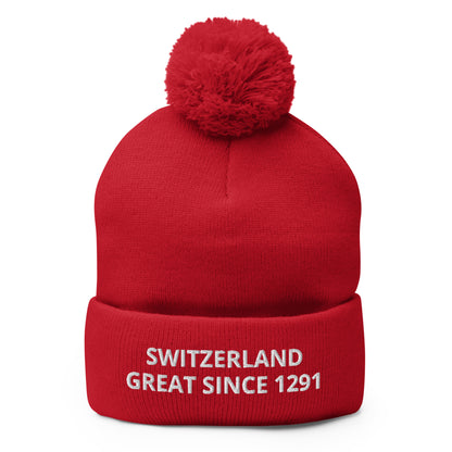 Front view of a red fold-over cuff beanie embroidered with “SWITZERLAND GREAT SINCE 1291”